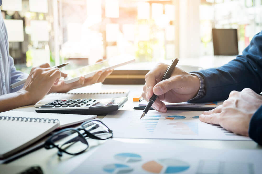 Contadores conferindo relatórios e gráficos financeiros